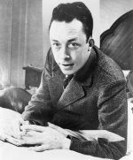 Albert_Camus,_gagnant_de_prix_Nobel,_portrait_en_buste,_posé_au_bureau,_faisant_face_à_gauche,...jpg