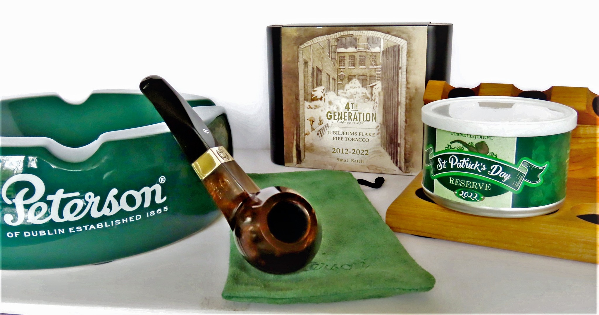 Sherlock Holmes Smooth Dark Stained Hudson is center stage. It came with Cornell& Diehl's St. Patrick's Day Special Reserve 2022 small batch blend of Bright Virginias, hazelnut, vanilla, a variety of canvendish and a smooth creamy topping. A lovely blend. In the background is 2021/2022 4th Generation limited edition Jubilaeums Flake, a tobacco blend dedicated to Erik Stokkebye's grandfather, Erik Poul. Photo by Fred Brown